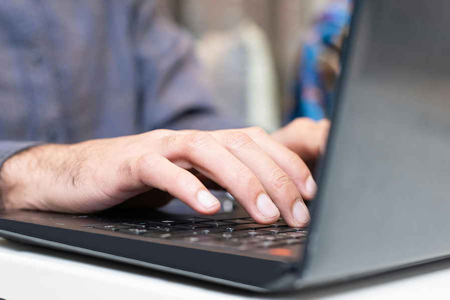 man typing on a laptop, focused on generating backlinks
